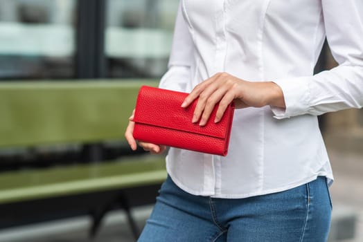 Girl in white holds a red wallet