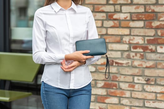 Girl in white holds a green wallet