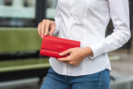 Girl in white holds a red wallet