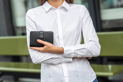 Girl in white holds a black wallet
