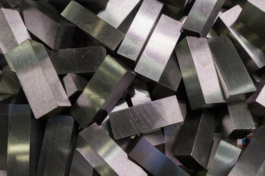 a pile of shiny faceted steel blocks - full frame close-up with selective focus, view directly from above