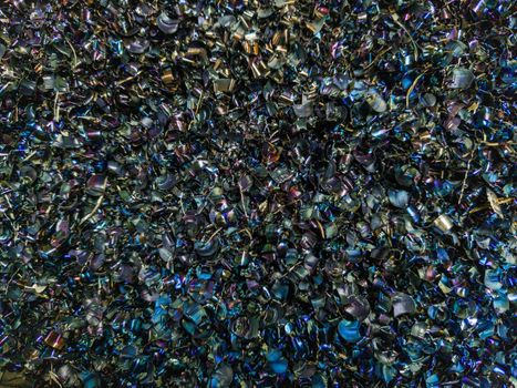Colored black Steel Chips flat background with natural thermal surface hardening discoloration.