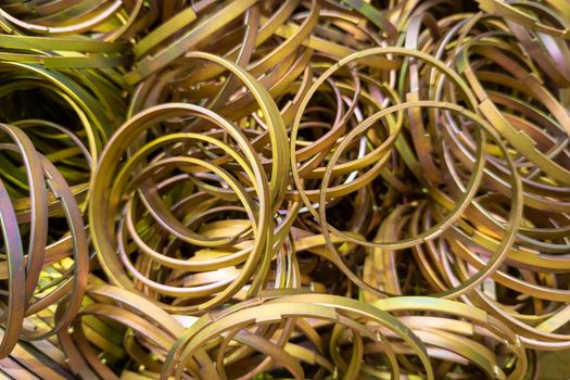cadmium with chromatization yellow protective coating on steel ring parts pile - full frame close-up background with selectivef focus and blur
