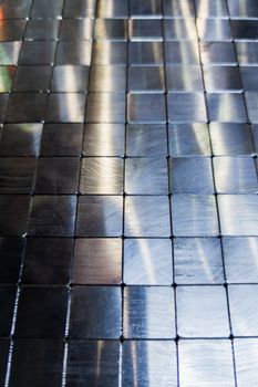 shiny steel machined blocks pavement surface background - close-up with selective focus and blur.
