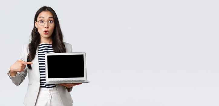 Business, finance and employment, female successful entrepreneurs concept. Enthusiastic businesswoman, asian office manager showing presenting on screen during meeting, pointing at laptop.