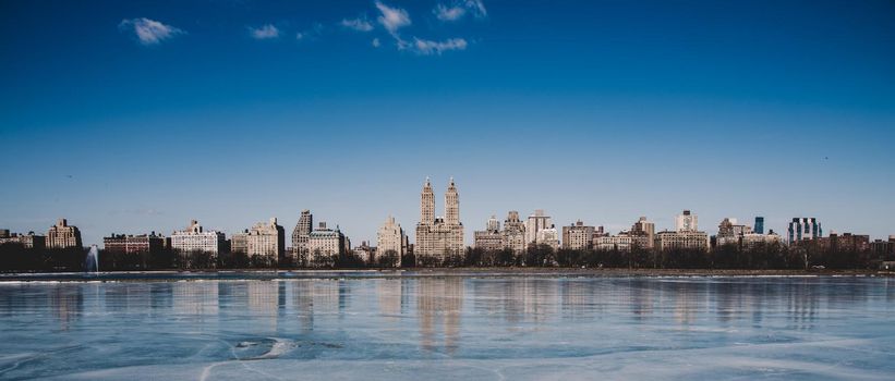 New York City - Panoramic view of modern buildings of upper west side Manhattan from Central Park with Jacqueline Kennedy Onassis Reservoir in winter