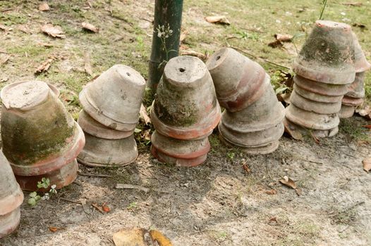 Stack of Earthen flower tubs on garden. Clay flower pots on the garden front yard.