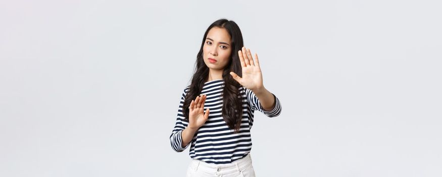 Lifestyle, beauty and fashion, people emotions concept. Annoyed woman feeling uncomfortable being photographed, asking turn-off camera, raising hands up defensive, protecting face from flashlight.