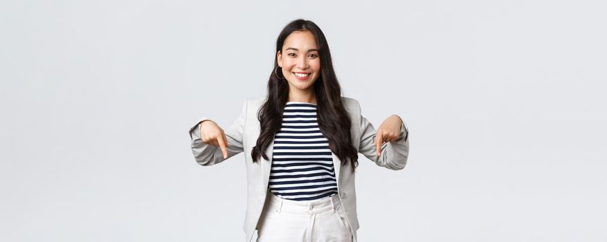 Business, finance and employment, female successful entrepreneurs concept. Confident professional female asian real estate broker showing good deal, pointing fingers down and smiling.