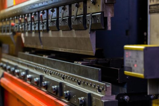 closeup view of hydraulic industrial sheet bending press brake with tool.