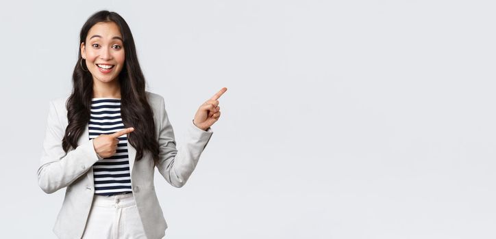 Business, finance and employment, female successful entrepreneurs concept. Friendly-looking cute female office manager glad to help, pointing upper right corner, showing way and smiling.