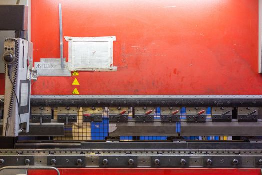 closeup view of hydraulic industrial sheet bending press brake with tool.