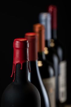 Set of collars red wine bottles isolated on black background, France