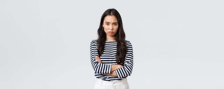 Lifestyle, people emotions and casual concept. Mad and offended cute silly asian girlfriend pouting, looking upset with hands crossed over chest, waiting for apology.
