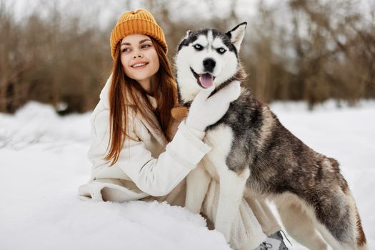 Happy young woman winter clothes walking the dog in the snow winter holidays. High quality photo