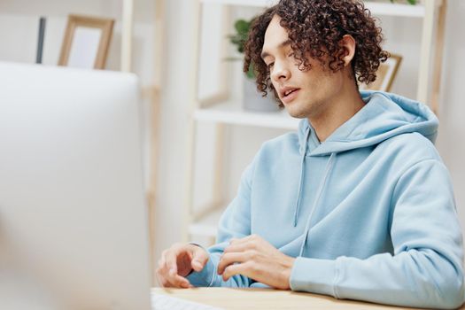 portrait of a man in a blue jacket in front of a computer with phone technologies. High quality photo