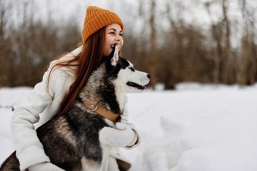 portrait of a woman winter clothes walking the dog in the snow winter holidays. High quality photo