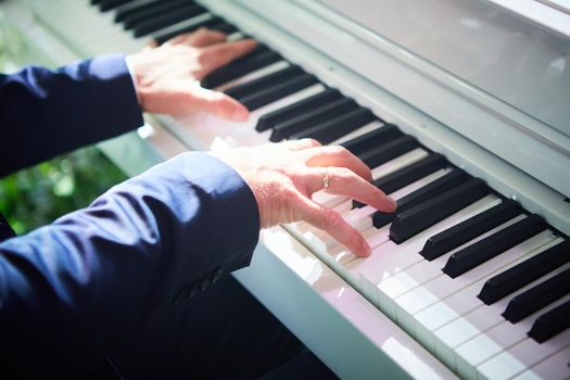 Closeup hand man playing piano. Classical music instrument. Fade color tone. Shallow dof