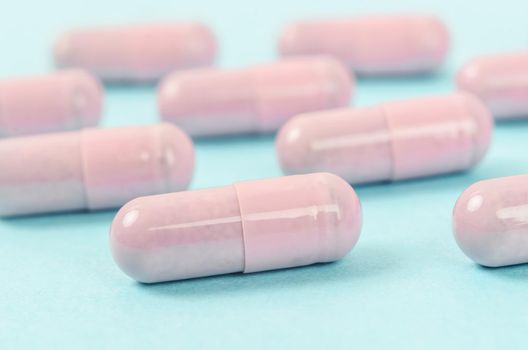 The Pink capsule pills on blue background