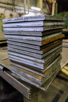 stack of rectangular thick sheet steel card workpieces, cut with guillotine shears.