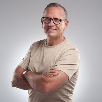 Shot of a handsome mature man standing alone against a grey background in the studio with his arms folded.