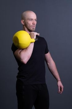 Guy with a yellow kettlebell gym anonymous yellow strength, in the afternoon fit effort for training for floor weightlifting, southeast fitness. Guy interval endurance, circuit hiit