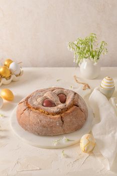 Portuguese traditional Easter cake. Folar with eggs on easter table. Blossom flowers and colorful painted eggs