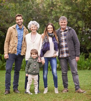 A multi-generation family standing outdoors.