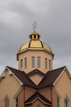 Golden domes orthodox church with cross against blue sky
