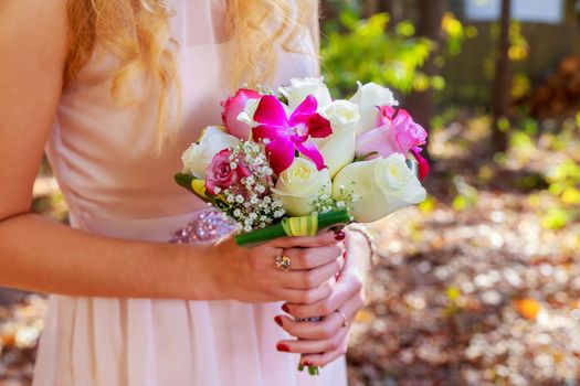 A nice wedding bouquet of purple, pink and white hold by a bride