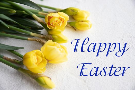 Easter greeting with a bouquet of daffodils and a text Happy Easter
