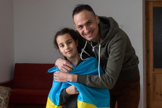 Father with daughter holding Ukrainian flag. Peace and pray for Ukraine.