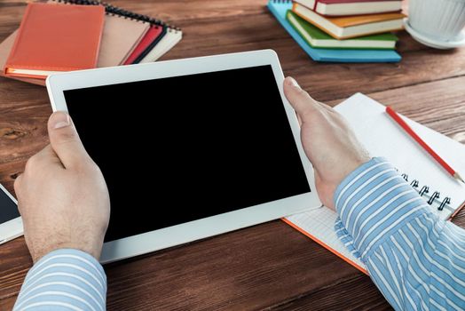 close-up of men's hands with a computer tablet. Businessman works in the office