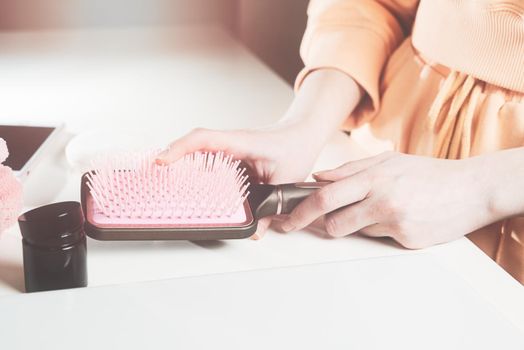 side view of bathroom accessories, hair brush, mobile phone, face sponge on a white surface.