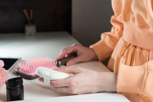 side view of bathroom accessories, hair brush, mobile phone, face sponge on a white surface.