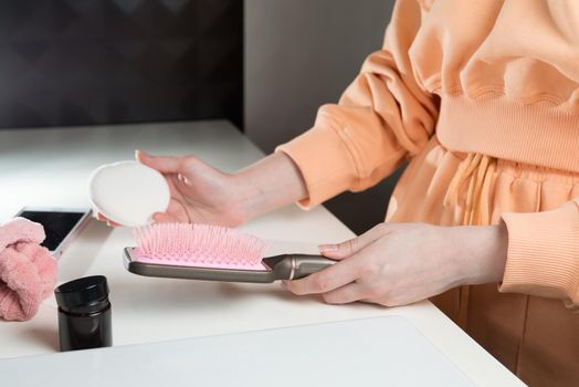 side view of bathroom accessories, hair brush, mobile phone, face sponge on a white surface.