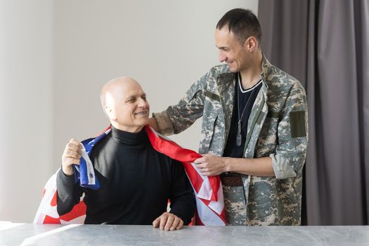 Soldier with his father with american flag on the background.