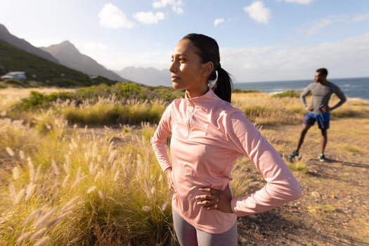 Fit african american couple in sportswear standing in tall grass. healthy lifestyle, exercising in nature.