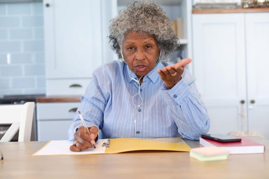 Portrait of african american senior female doctor talking looking at the camera at home. distant communication and telemedicine consultation concept.