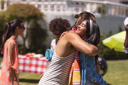 Diverse group of friends greeting each other at a pool party. Hanging out and relaxing outdoors in summer.