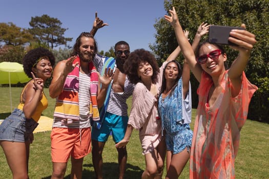 Diverse group of friends taking selfie at a pool party. Hanging out and relaxing outdoors in summer.