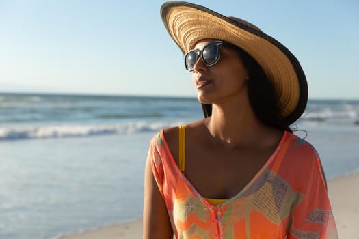 Portrait of mixed race woman on beach holiday. healthy outdoor leisure time by the sea.