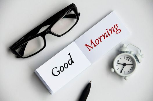 Good morning text on notepad with pen and Glasses. Morning greeting concept