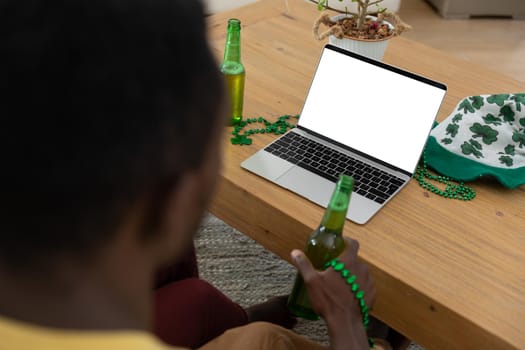 African american couple wearing st patrick's day costumes making a video call. staying at home in isolation during quarantine lockdown.