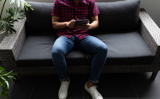 Mixed race businessman working in creative office. man sitting and using tablet. social distancing in workplace during covid 19 pandemic.