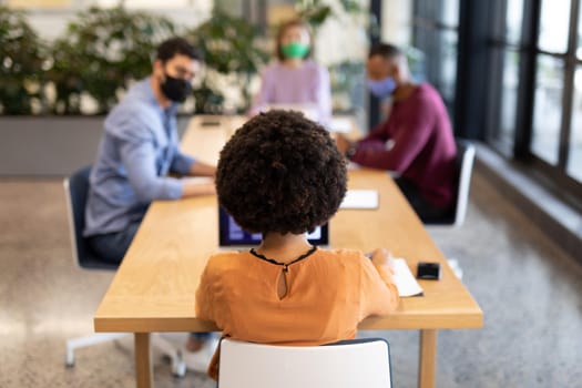 Diverse group of business people working in creative office. group of people in a meeting discussing work. social distancing protection hygiene in workplace during covid 19 pandemic.