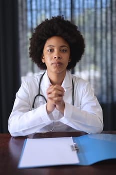 African american female doctor sitting making video call consultation. telemedicine online with doctor during quarantine lockdown.