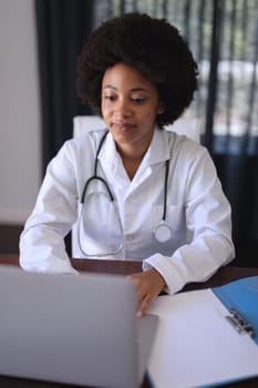 African american female doctor sitting making video call consultation. telemedicine online with doctor during quarantine lockdown.