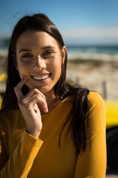 Portrait of happy caucasian woman on beach by the sea looking to camera. beach break on summer holiday road trip.