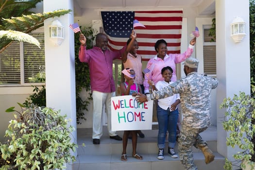 African american soldier father greeting his happy three generation family outside house. soldier returning home to family.